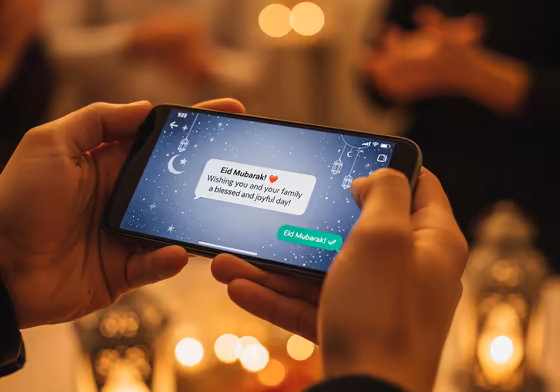 A smartphone screen showing a festive Eid Mubarak message being sent on a messaging app.